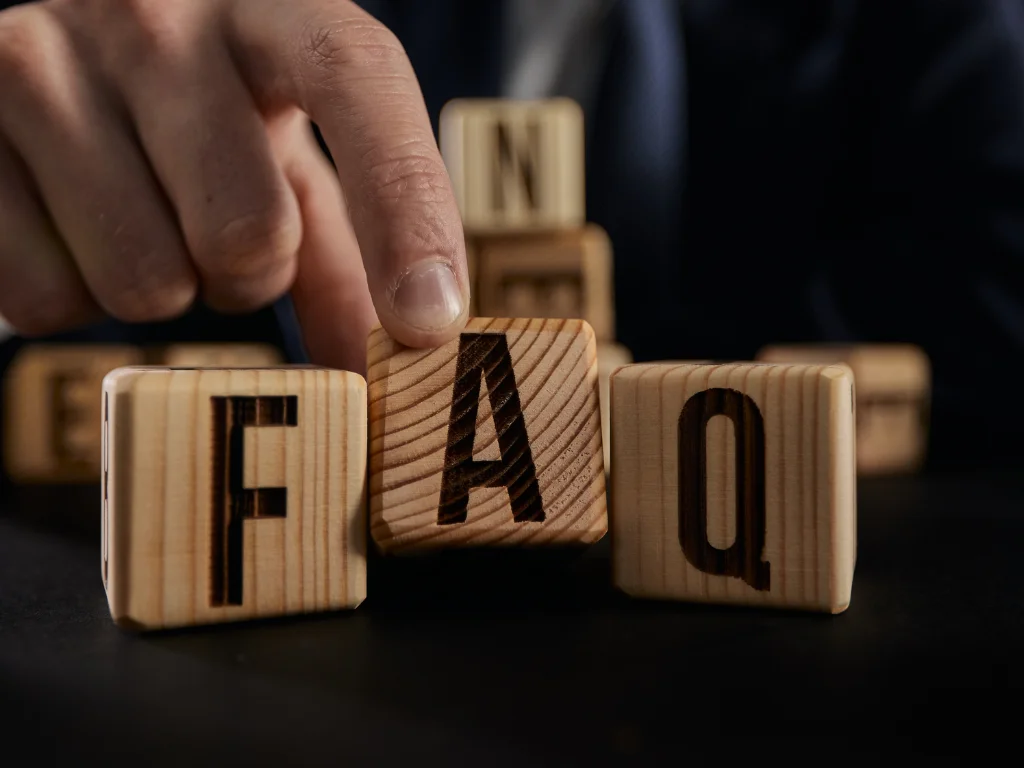 businessman puts wooden blocks with word faq