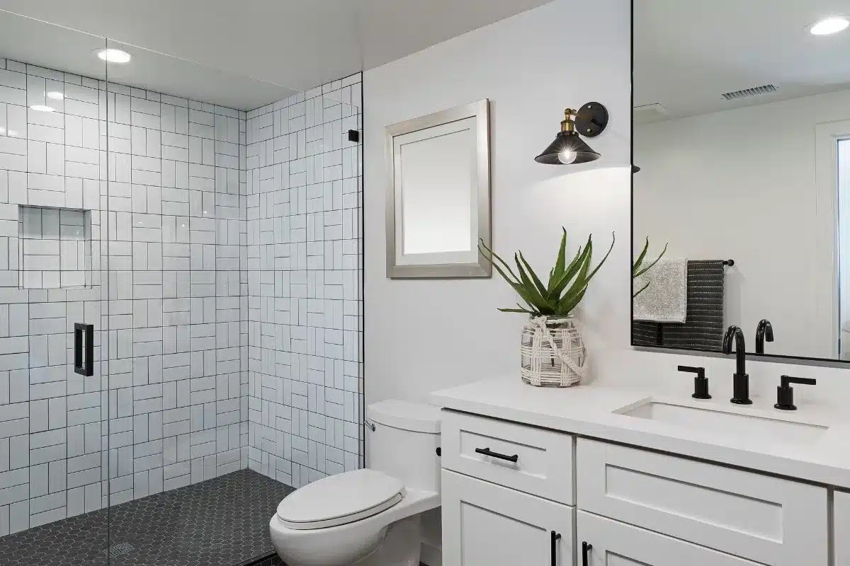 Modern bathroom remodel ideas with walk-in glass shower, white subway tile, black hex floor, and matte black fixtures