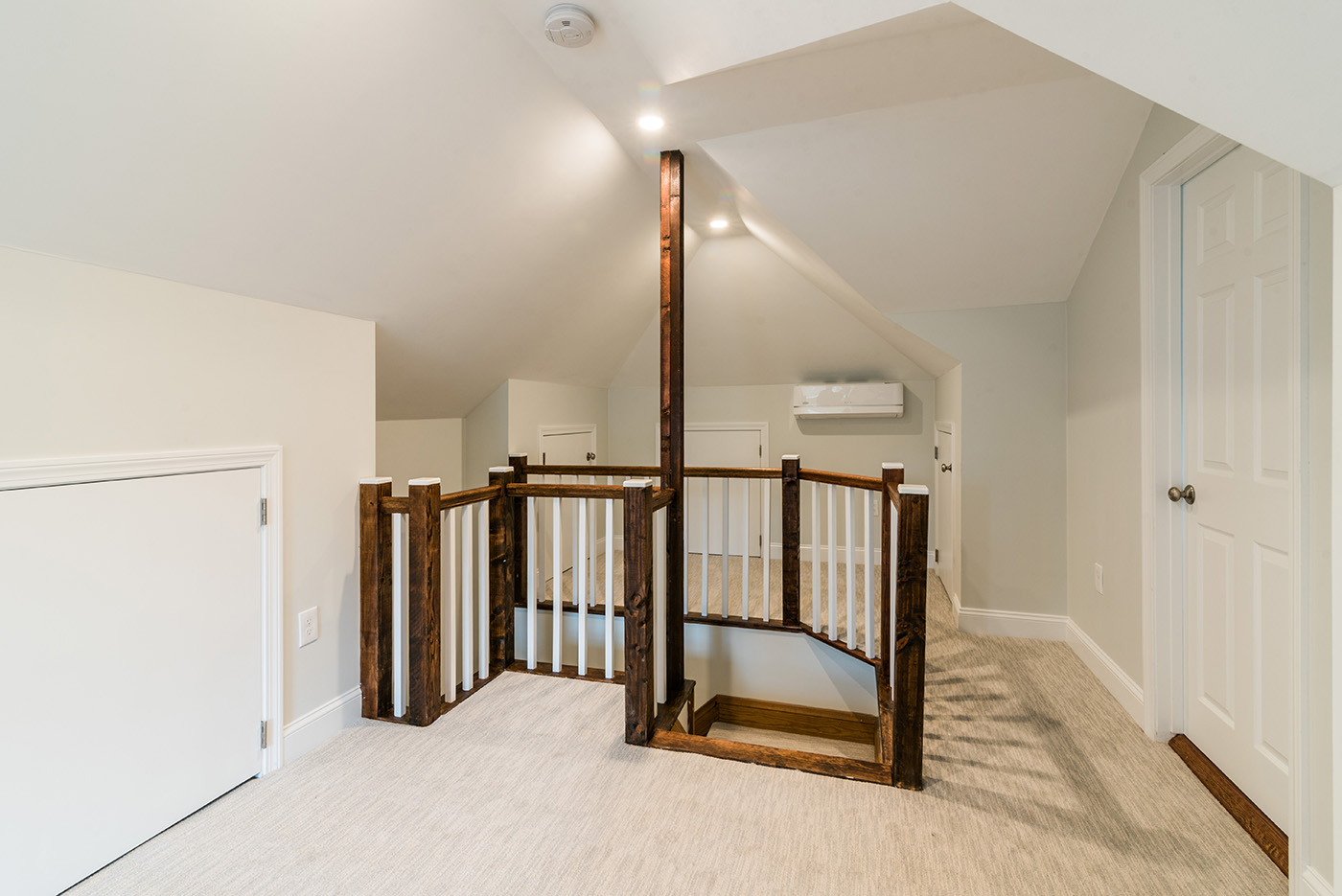 Stair rail and knee-wall storage doors in a completed Belmont attic.